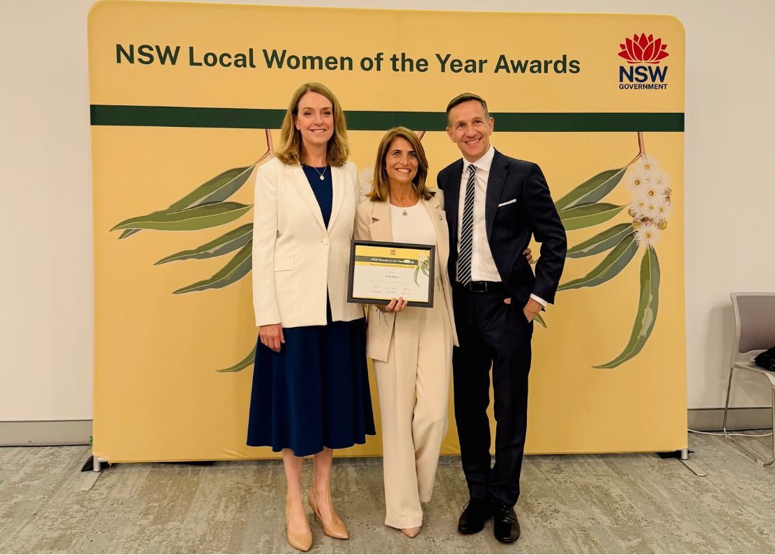 Three people standing in front of a backdrop for the NSW Local Women of the Year Awards.